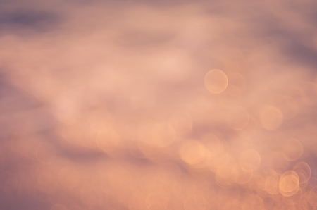 Blur tropical sunset beach with bokeh sun light wave abstract background. Travel concept. Retro color style.の写真素材