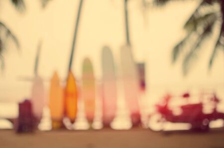 Blur surfboard and palm leaf on tropical beach abstract background. Travel concept. Retro color style.の写真素材