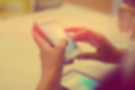Blur woman using smart phone abstract background. Retro color style.の写真素材