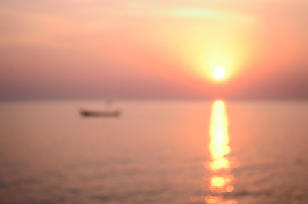 Blur tropical sunset beach with bokeh sun light wave abstract background. Travel concept. Retro color style.の写真素材