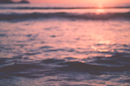 Blur tropical sunset beach with bokeh sun light wave abstract background. Travel concept. Retro color style.の写真素材