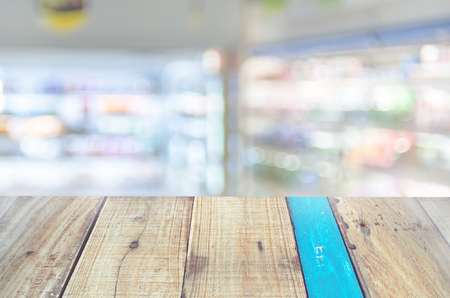 Blur supermarket shelf abstract background on old wood wall wood table background.の写真素材