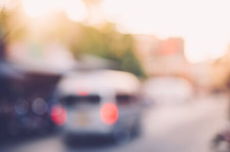 Blur traffic road with colorful bokeh light in sunset abstract background. Travel and transportation concept. Vintage tone color filter.の写真素材