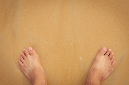 Selfie foots on sand beach texture background. Copy space of summer vacation and travel adventure concept. Retro tone filter color style.の写真素材