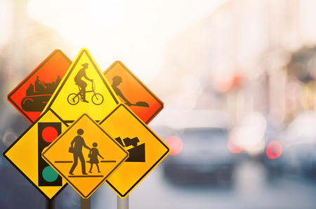 Set of traffic warning sign on blur traffic road with colorful bokeh light abstract background. Copy space of transportation and travel concept. Retro tone filter color style.の写真素材