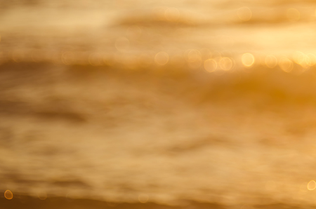 Blur tropical sunset beach with bokeh sun light wave abstract background. Copy space of summer vacation and business travel concept. Vintage tone color filter style.の写真素材