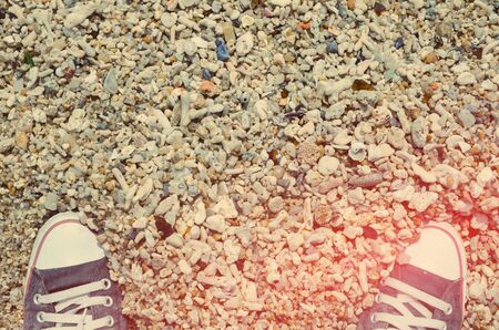Top view of shoes on dried coral sand beach background, selfie. Copy space of travel adventure and nature environment concept.Retro tone filter color style.の写真素材