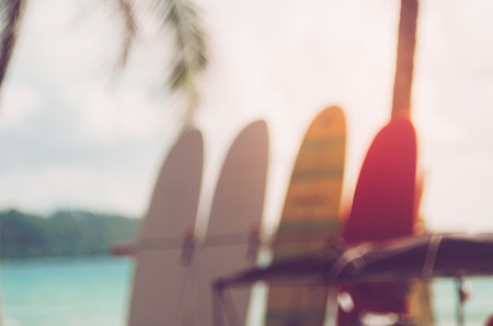 Blur colorful surfboard on tropical sand island beach abstract background. Copy space of summer vacation and extreme water sport concept. Retro tone filter color style.の写真素材