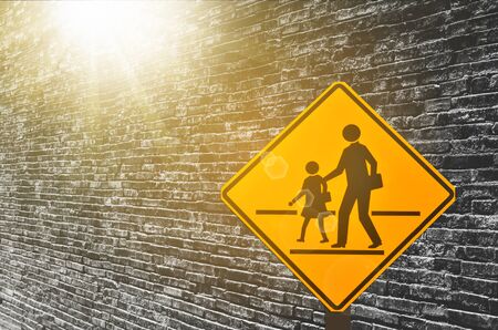 School warning sign on old grunge brown stone brick wall texture abstract background. Copy space of...