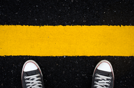 Top view of shoes and traffic line sign on street background, selfie. Copy space of travel adventure and transportation concept. Retro tone filter color style.の写真素材