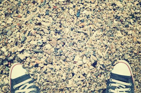 Top view of shoes on dried coral sand beach background, selfie. Copy space of travel adventure and nature environment concept.Retro tone filter color style.の写真素材