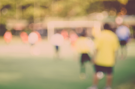 Blur kids playing football abstract background. Vintage tone filter.の写真素材