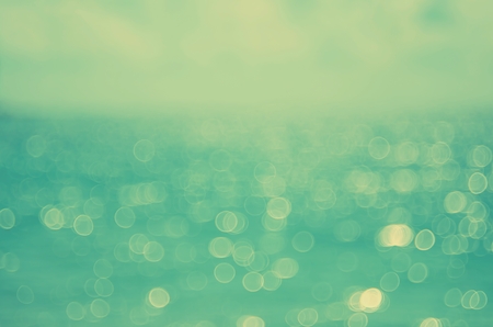 Blur tropical beach with bokeh sun light wave abstract background. Copy space of summer vacation and business travel concept. Vintage tone color filter style.の写真素材