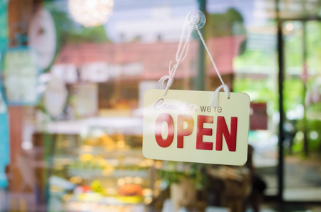Open sign broad through the glass of door in cafe. Business and service concept.