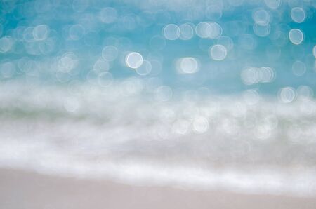 Blur tropical beach with bokeh sun light wave abstract background. Copy space of summer vacation and business travel concept. Vintage tone color filter style.の写真素材