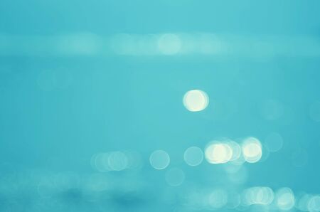 Blur tropical beach with bokeh sun light wave abstract background. Copy space of outdoor summer vacation and business travel concept. Vintage tone filter color style.の写真素材