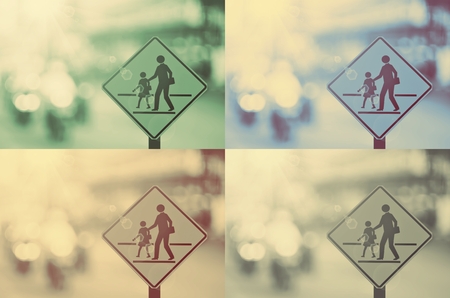 Set of school zone warning sign on blur traffic road with colorful bokeh light abstract background. Copy space of transportation and travel concept. Vintage tone filter color style.の写真素材