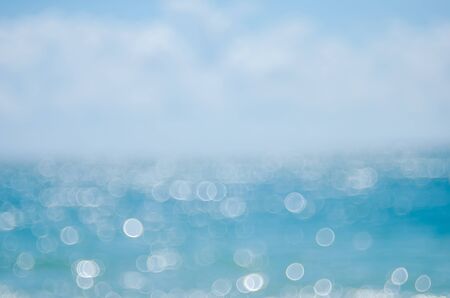 Blur tropical beach with bokeh sun light wave abstract background. Copy space of summer vacation and business travel concept. Vintage tone color filter style.の写真素材