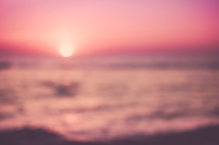 Blur tropical sunset beach with bokeh sun light wave abstract background. Copy space of outdoor summer vacation and business travel concept. Vintage tone filter color style.の写真素材