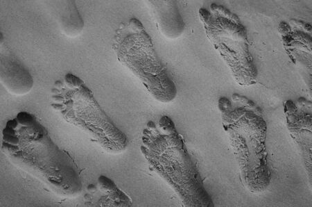 Close up of many footprints on sand beach texture background. Copy space of summer vacation and...