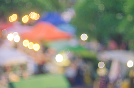 Blur people shopping in local street market with colorful bokeh and sun light abstract background. Copy space of travel and business concept. Vintage tone filter color style.の写真素材