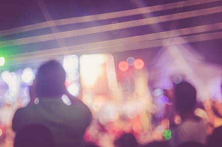 Blur people taking smart phone in night outdoor concert with colorful bokeh abstract background....