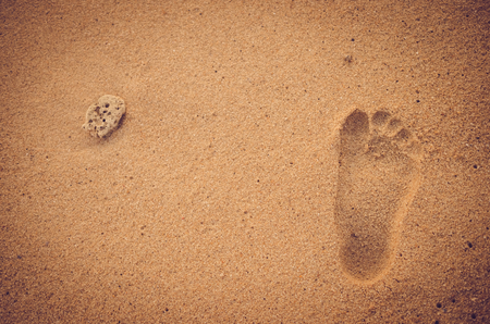 Copy space of footprint on sand beach with dried coral. Travel concept. Retro color style.の写真素材