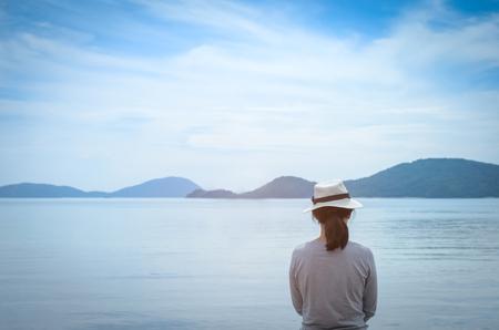 Travel adventure and freedom concept. Copy space female looking view of beach background. Vintage tone filter color style.の写真素材