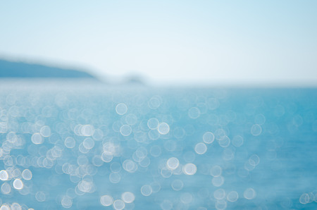 Blur tropical beach with bokeh sun light wave abstract background. Travel concept. Retro color style.の写真素材