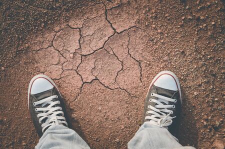 Top view of shoes and blue jean on ground with colorful small rock sand  background, selfie. Copy space of fashion and travel adventure concept. Vintage tone color style.の写真素材