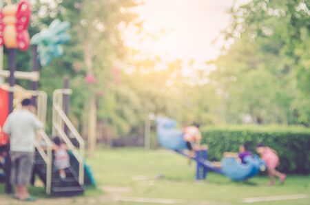 Blur kids playing playground in park abstract background. Copy space of sport exercise and health care concept. Vintage tone filter color style.の写真素材
