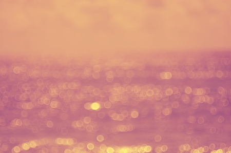 Blur tropical beach with bokeh sun light wave abstract background. Copy space of outdoor summer vacation and travel adventure concept. Vintage tone filter color style.の写真素材