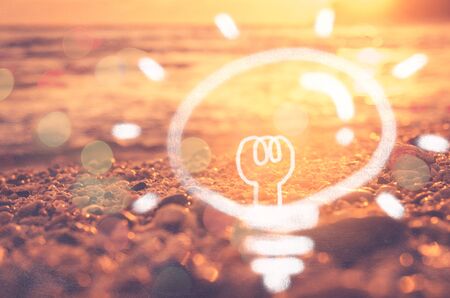 Idea creative thinking in nature and outdoor summer vacation freedom concept.Blur tropical sunset beach bokeh wave double exposure light bulb texture background.の写真素材