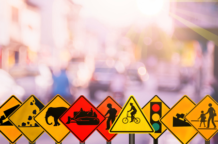Set of traffic warning sign on blur traffic road with colorful bokeh light abstract background. Copy space of transportation and travel concept. Retro tone filter color style.の写真素材