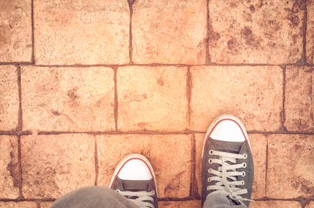 Top view of shoes on street texture background, selfie. Copy space of travel adventure and freedom concept. Retro tone filter color style.の写真素材