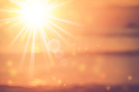 Blur tropical sunset beach with bokeh sun light wave abstract background. Copy space of outdoor summer vacation and travel adventure concept. Vintage tone filter color style.の写真素材