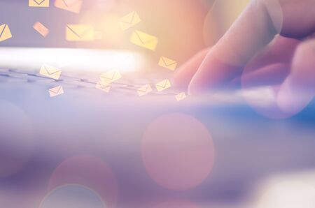 Business economic technology and working connect concept. Close up man hand using notebook double exposure email fly draw graphic colorful bokeh background. Vintage tone filter effect color style.の写真素材