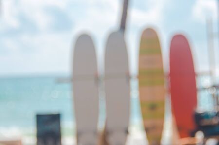 Blur colorful surfboard and palm leaf on tropical island beach abstract background. Copy space of summer vacation and extreme water sport concept. Retro tone filter color style.の写真素材