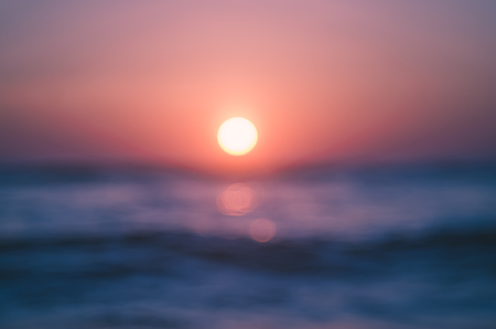 Blur tropical sunset beach with bokeh light wave abstract background. Copy space of outdoor summer vacation and business travel adventure concept. Vintage tone filter effect color style.の写真素材