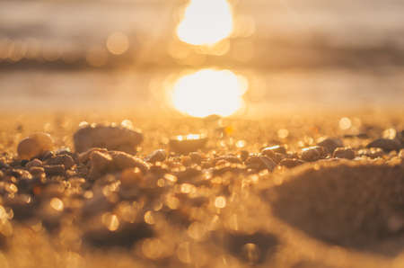 Blur tropical sunset beach with bokeh light sand abstract texture background. Copy space of outdoor summer vacation and business travel adventure concept. Vintage tone filter effect color style.の写真素材