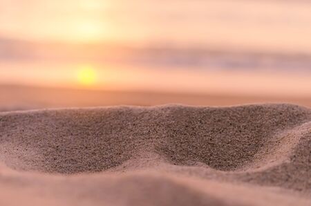 Blur tropical sunset beach with bokeh light sand abstract texture background. Copy space of outdoor summer vacation and business travel adventure concept. Vintage tone filter effect color style.の写真素材