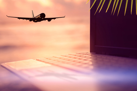 Copy space business economic technology working and travel adventure lifestyle concept. Airplane fly over palm leaf tropical sunset beach and notebook background. Vintage filter effect color styleの写真素材