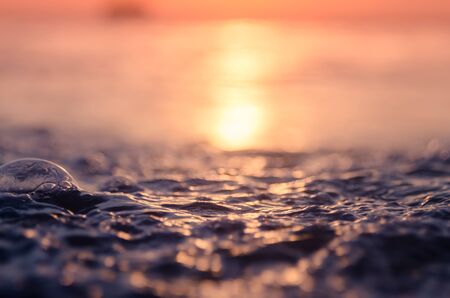 Blur tropical sunset beach with bokeh light wave abstract background. Copy space of outdoor summer vacation and business travel adventure concept. Vintage tone filter effect color style.の写真素材