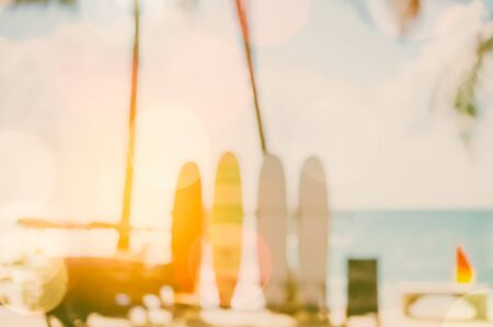 Blur colorful surfboard and palm leaf on tropical island beach abstract background. Copy space of summer vacation and extreme water sport concept. Retro tone filter color style.の写真素材