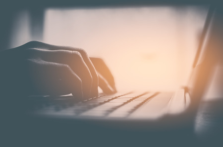 Business economic and technology working concept. Close up woman hand using keyboard notebook. Shallow depth of field. Vintage tone filter effect color style.の写真素材