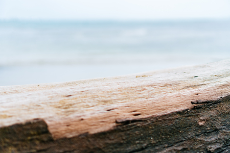 Blur tropical beach with bokeh sun light wave on empty old wood table abstract background. Product presentation in nature. Vintage tone filter color style.の写真素材