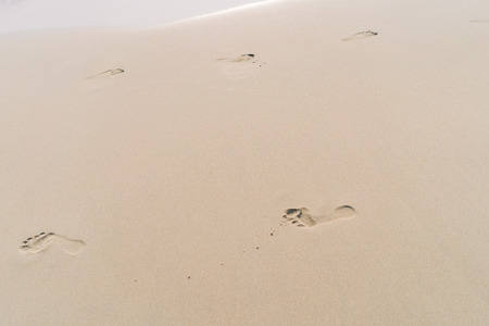 Copy space of footprint on sand beach texture abstract background. Summer vacation and business travel freedom adventure concept. Vintage tone filter effect color style.の写真素材