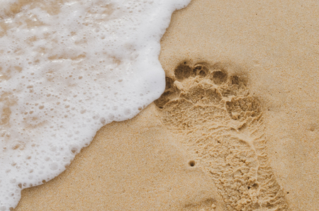 Copy space of smooth wave and footprint on sand beach texture background. Summer vacation and business travel freedom adventure concept. Vintage tone filter effect color style.の写真素材