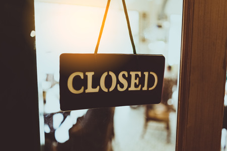 Old Close sign hanging front of cafe mirror door. Business service and food drink concept. Vintage...