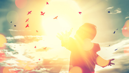 Freedom feel good and travel adventure concept. Copy space of silhouette man rising hands on sunset sky double exposure colorful bokeh and bird fly background. Vintage tone filter effect color style.の写真素材